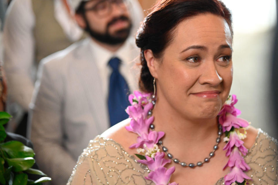 Close-up of Stacey  with a necklace and floral neck adornment