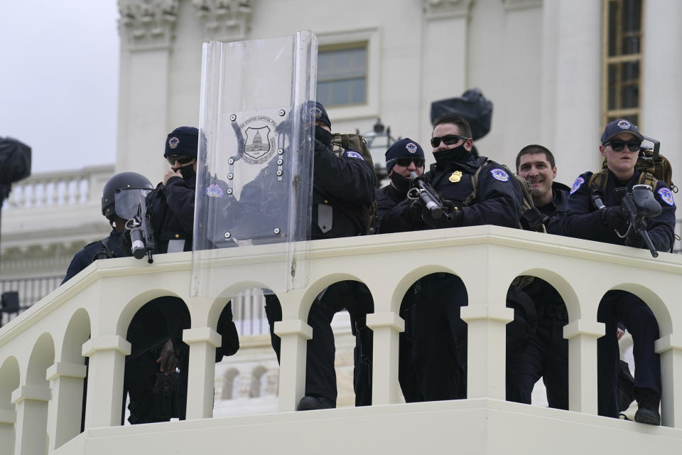 In this Wednesday, Jan. 6, 2021, photo, U.S. Capitol Police officer stand as violent rioters storm the Capitol, in Washington. The top watchdog for the U.S. Capitol Police will testify to Congress for the first time about the department’s broad failures before and during the Jan. 6 insurrection. Among them was missed intelligence and old weapons that officers didn’t feel comfortable using. (AP Photo/John Minchillo)