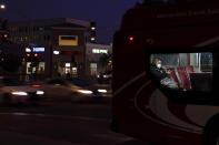 A person wears a mask to prevent the spread of coronavirus on a city bus Tuesday, Nov. 24, 2020, in San Diego. California's health secretary urged people to say "no" to family and friends who want to gather for Thanksgiving, joining other officials in issuing dire warnings about the spread of the coronavirus. (AP Photo/Gregory Bull)