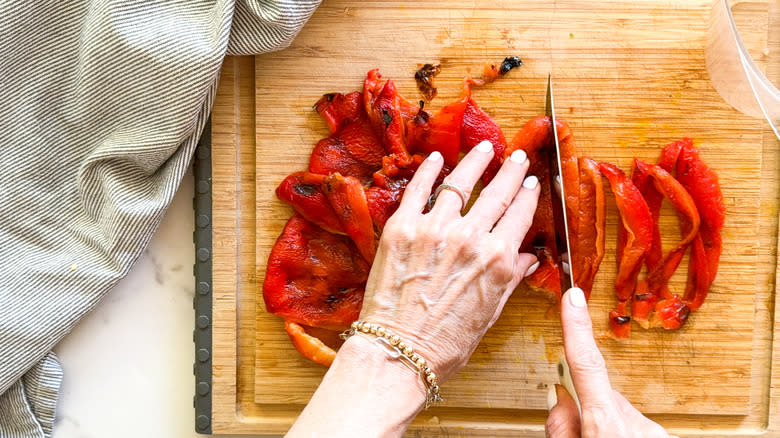 slicing red peppers on cutting board