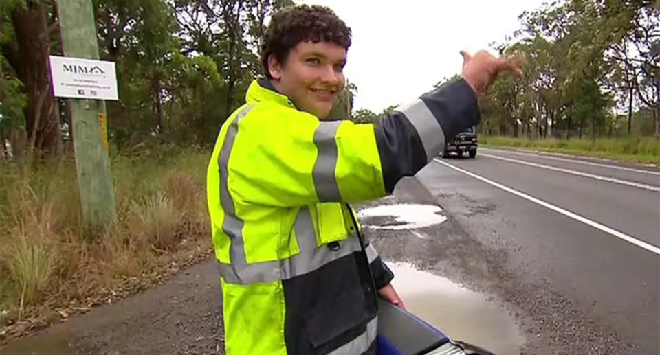 Beau Jackson waves to drivers as he warns them about a speed camera ahead.