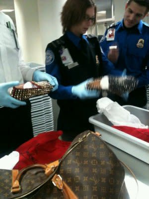 TSA officials examine the potentially dangerous shoes. Photo via @TazArnold