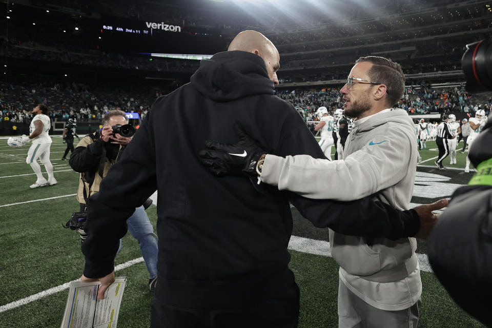 New York Jets head coach Robert Saleh, left, and Miami Dolphins head coach Mike McDaniel meet on the field after an NFL football game, Friday, Nov. 24, 2023, in East Rutherford, N.J. (AP Photo/Adam Hunger)