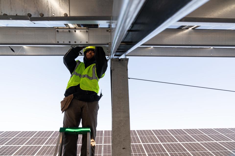 Elias Her Many Horses of Good Energy Solutions works on installing a commercial scale solar project in Topeka, Kansas, Nov. 1, 2023.