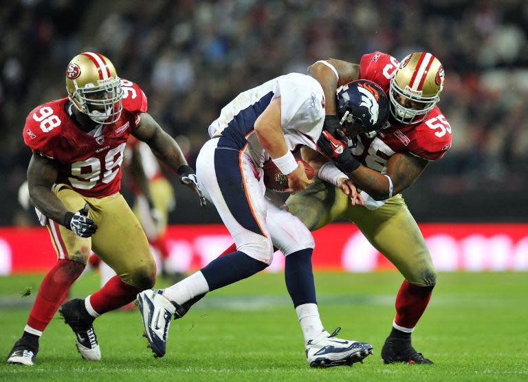 Ahmad Brooks of the San Francisco 49ers (R) tackles Kyle Orton of the Denver Broncos (C) during their NFL International series game at Wembley Stadium in London on October 31, 2010