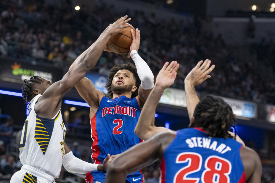 Detroit Pistons guard Cade Cunningham (2) shoots while being defended by Indiana Pacers guard Bennedict Mathurin during the first half of an NBA basketball game in Indianapolis, Saturday, Oct. 22, 2022. (AP Photo/Doug McSchooler)