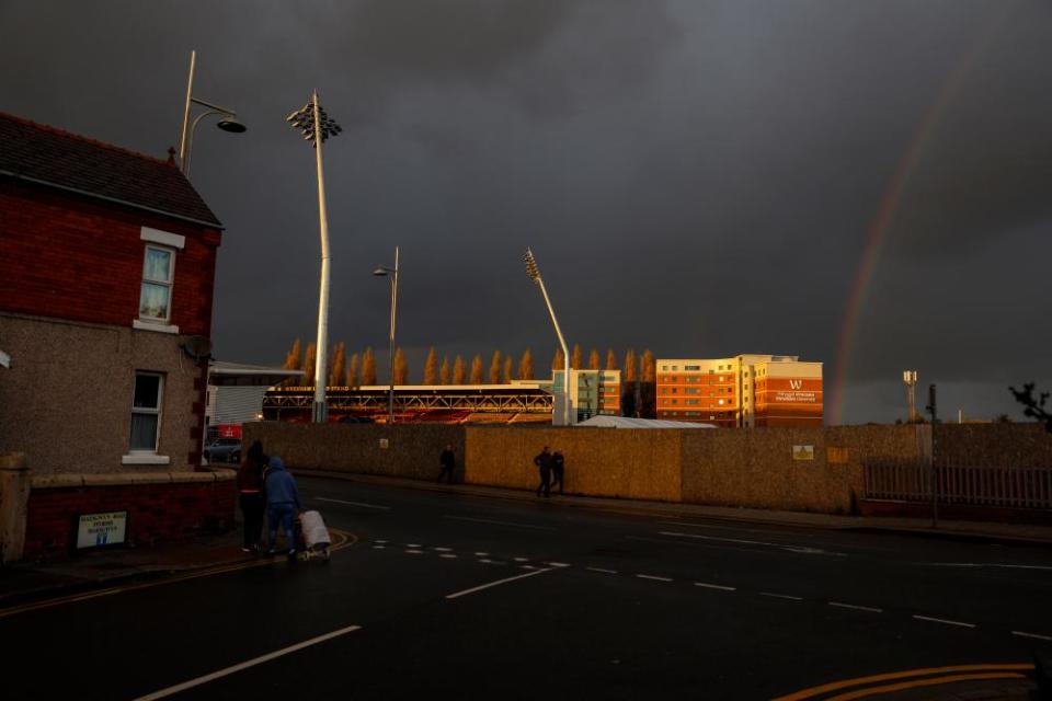 Golden light hits the ground as a rainbow forms after the match with Salford