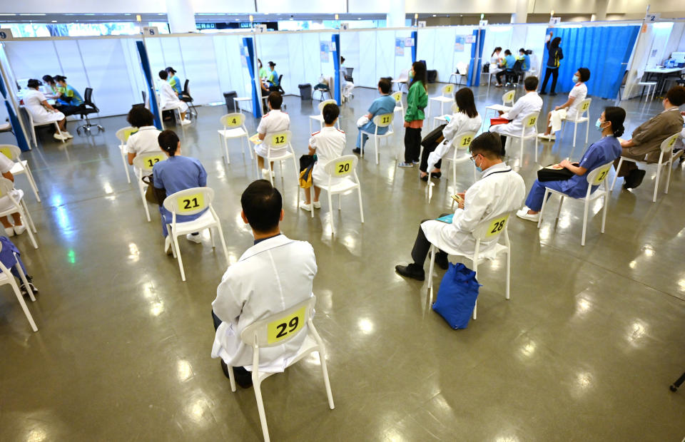 Doctors and nurses wait to receive China's Sinovac COVID-19 coronavirus vaccine at a community vaccination centre in Hong Kong Tuesday, Feb. 23, 2021. Frontline workers and high risk people are the first in line to be vaccinated in the territory. (Peter Parks/Pool Photo via AP)