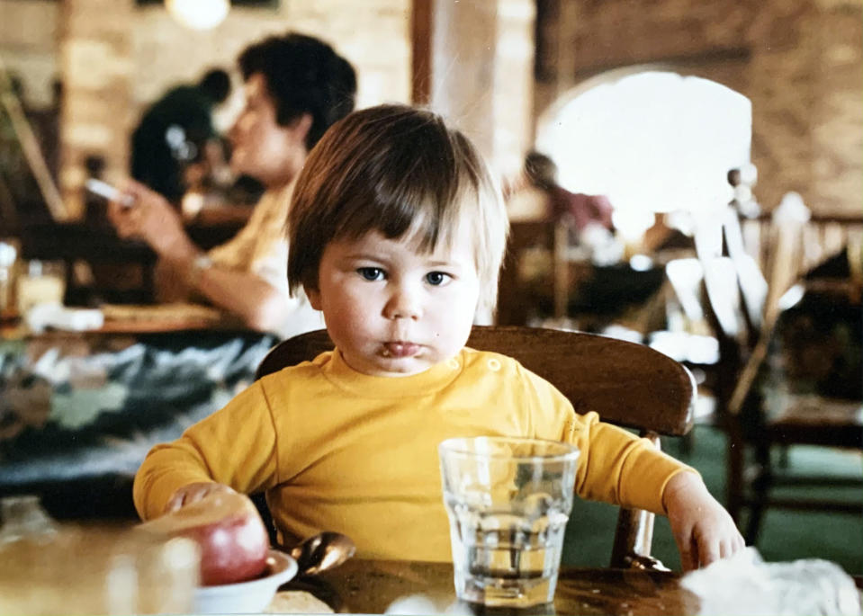 In this image provided by the Pete Buttigieg presidential campaign, Pete Buttigieg sits at a table while visiting his grandmother in Malta around 1984. (Pete Buttigieg Presidential Campaign via AP)