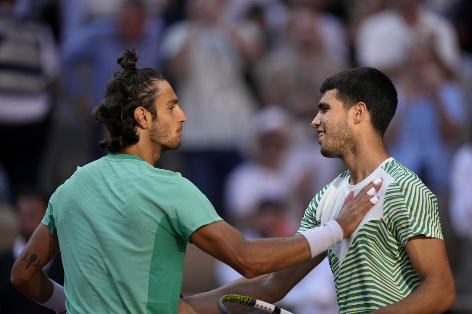 Italy's Lorenzo Musetti, left, shakes hands with Spain's Carlos Alcaraz after their fourth round match of the French Open tennis tournament at the Roland Garros stadium in Paris, Sunday, June 4, 2023. (AP Photo/Thibault Camus)