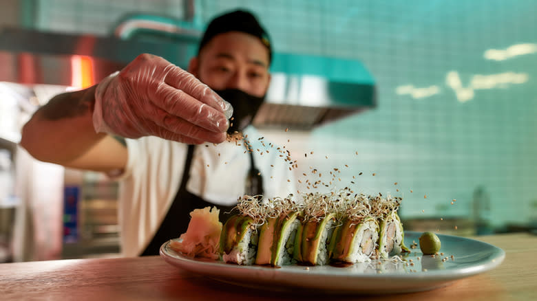 sushi chef making maki rolls