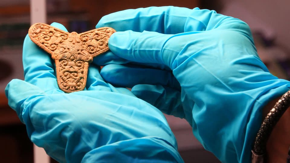 A conservator at Museum Odense displays a brooch found in a Viking-age burial site during an interview with journalists in Odense, Denmark, September 25, 2024. REUTERS/Tom Little  - Tom Little/Reuters