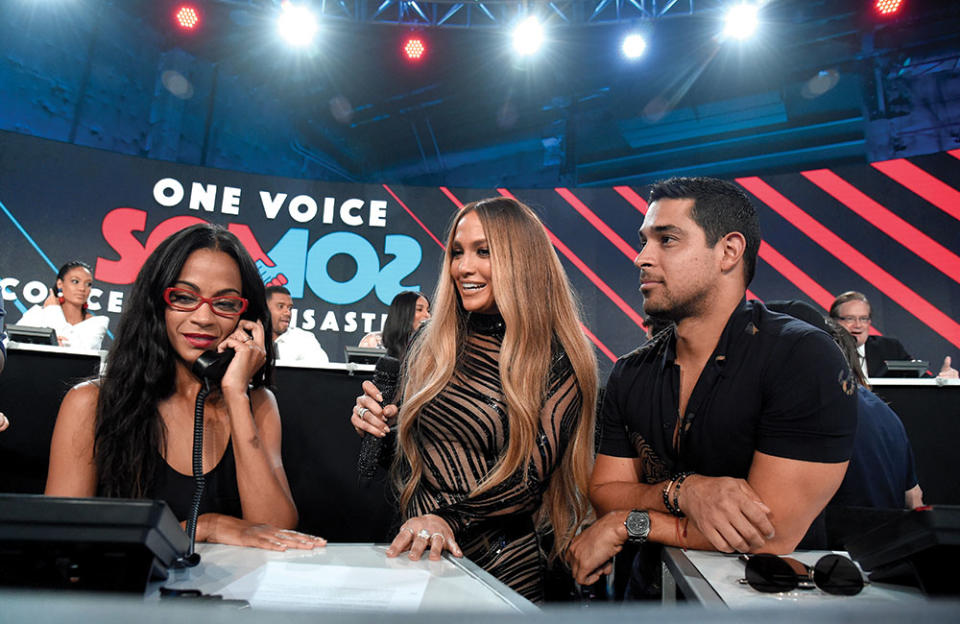 From left: Zoe Saldaña, Jennifer Lopez and Wilmer Valderrama work the phones during One Voice: Somos Live! A Concert for Disaster Relief at the Universal Studios lot in 2017 - Credit: Kevin Mazur/One Voice: Somos Live!/Getty Images