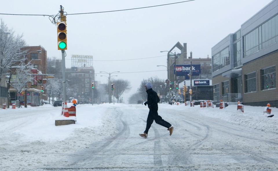 A man runs across the street in Milwaukee, Wisconsin