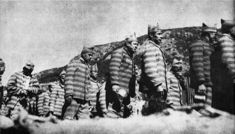 A black-and-white photo of inmates in a line.