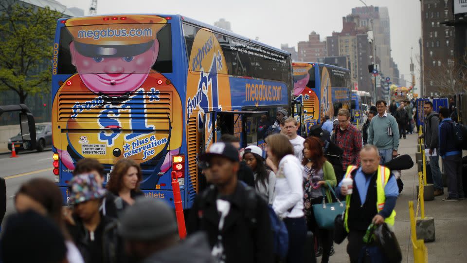 Passengers line up to board Megabus buses in New York City in 2014. Curbside carries have drawn new riders but do not usually have facilities. - Eduardo Munoz/Reuters