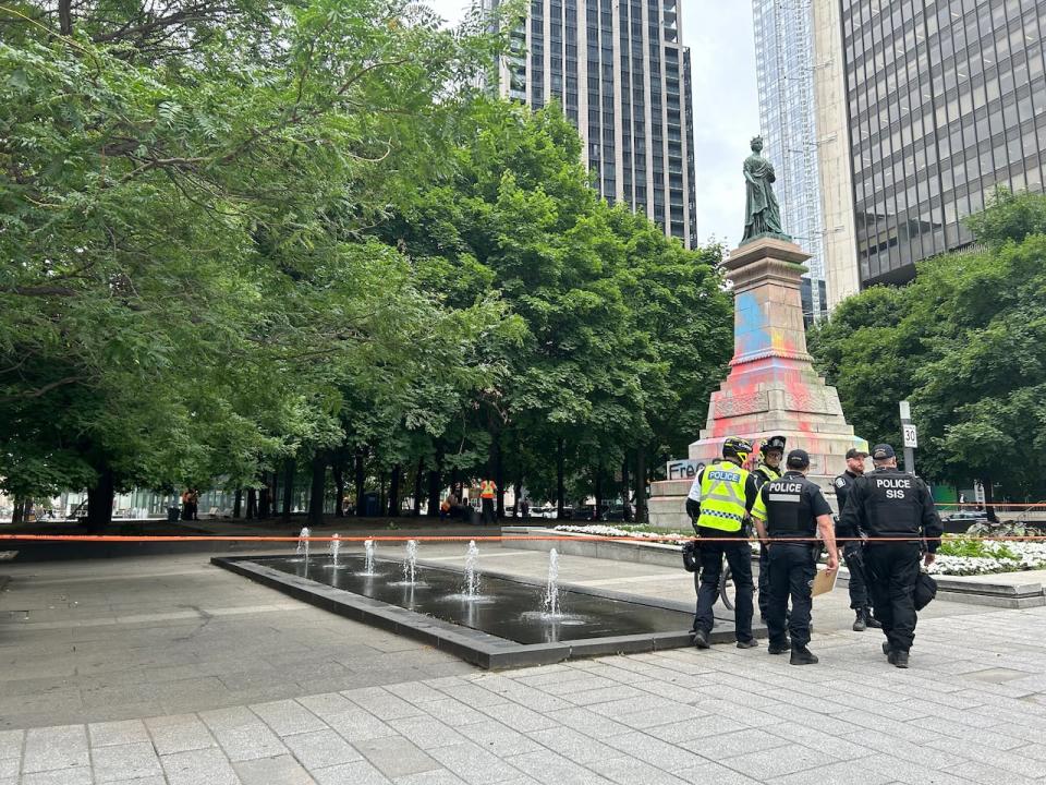 Montreal police walk in Victoria Square as city workers finish cleaning up the remnants of a pro-Palestinian protest encampment. 