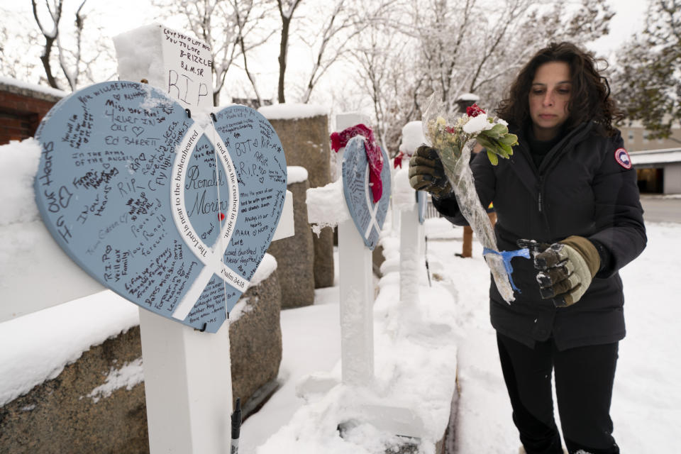 Rachel Ferrante, executive director of the Maine Mill, gathers items from a makeshift memorial for the victims of last month's mass shooting in Lewiston, Maine, Tuesday, Dec. 5, 2023. The items will be cataloged, archived and displayed in the museum. (AP Photo/Robert F. Bukaty)