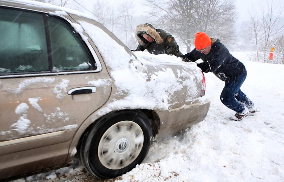 <p>In this frame from a video, two good Samaritans push a car whose driver was was stuck in deep snow during a snowstorm, March 8, 2018, in Freeport, Maine. (Photo: Robert F. Bukaty/AP) </p>