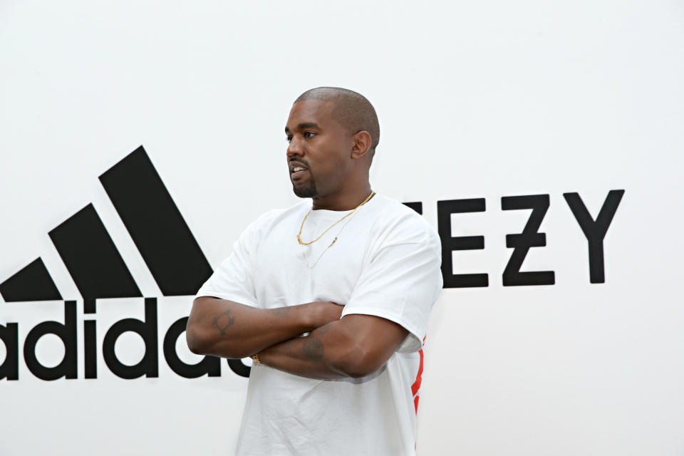 Kanye West wearing white t-shirt with arms folded