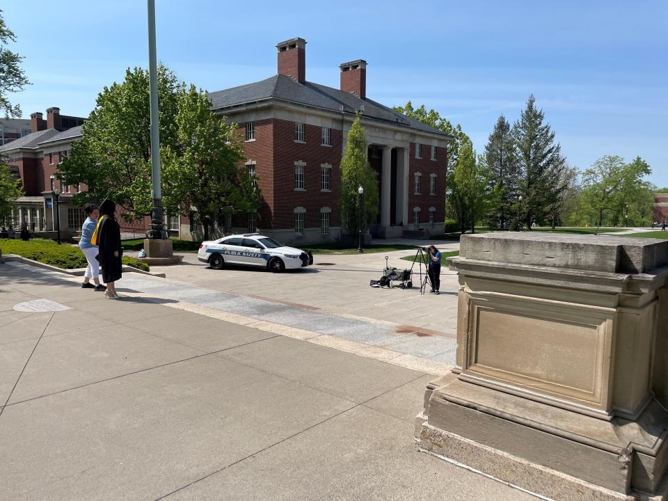 Students prepare for commencement at the University of Rochester on May 14, 2024, with Department of Public Safety officers stationed nearby.