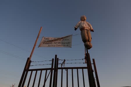 An effigy of a person is displayed on a fence next to a banner reading "No more robberies. People caught stealing will be burned. Community justice" in the Cherro Chuno neighbourhood, near the Chilean and Peruvian border, in Arica, Chile, November 18, 2018. REUTERS/Ivan Alvarado