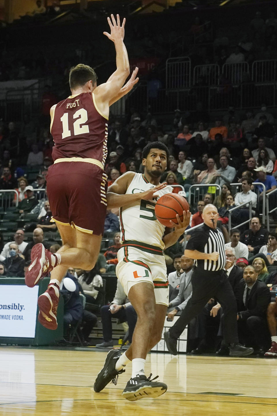 Miami guard Harlond Beverly (5) drives to the basket as Boston College forward Quinten Post (12) defends during the first half of an NCAA college basketball game, Wednesday, Jan. 11, 2023, in Coral Gables, Fla. (AP Photo/Marta Lavandier)