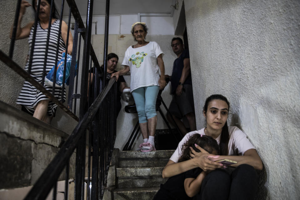 People in Ashdod, Israel take shelter in the stairwell of their apartment building during a siren warning of rockets fired from Gaza to Israel on May 18, 2021.(AP Photo/Heidi Levine)