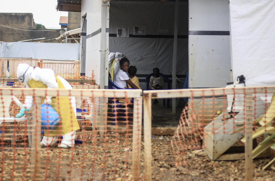 A woman whose 5-year-old daughter had a fever and was vomiting sits with her in an Ebola transit center where potential cases are evaluated, after being transported there by motorcycle taxi driver Germain Kalubenge, in Beni, Congo, Thursday, Aug. 22, 2019. Kalubenge is a rare motorcycle taxi driver who is also an Ebola survivor in eastern Congo, making him a welcome collaborator for health workers who have faced deep community mistrust during the second deadliest Ebola outbreak in history. (AP Photo/Al-hadji Kudra Maliro)