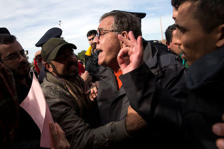 Greek Migration Minister Yannis Mouzalas (C) talks with protesting refugees and migrants, most of them Afghans, at the refugee camp at the disused Hellenikon airport in Athens, Greece, February 6, 2017. REUTERS/Alkis Konstantinidis