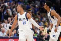 Dallas Mavericks guard Jalen Brunson (13) and Spencer Dinwiddie, right, celebrate a 3-point basket made by Brunson in the first half of Game 2 of an NBA basketball first-round playoff series against the Utah Jazz, Monday, April 18, 2022, in Dallas. (AP Photo/Tony Gutierrez)