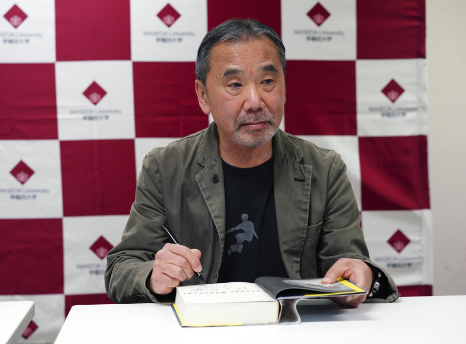 Japanese novelist Haruki Murakami signs his autograph on his novel "Killing Commendatore" during a press conference at Waseda University in Tokyo Saturday, Nov. 3, 2018. (AP Photo/Eugene Hoshiko)