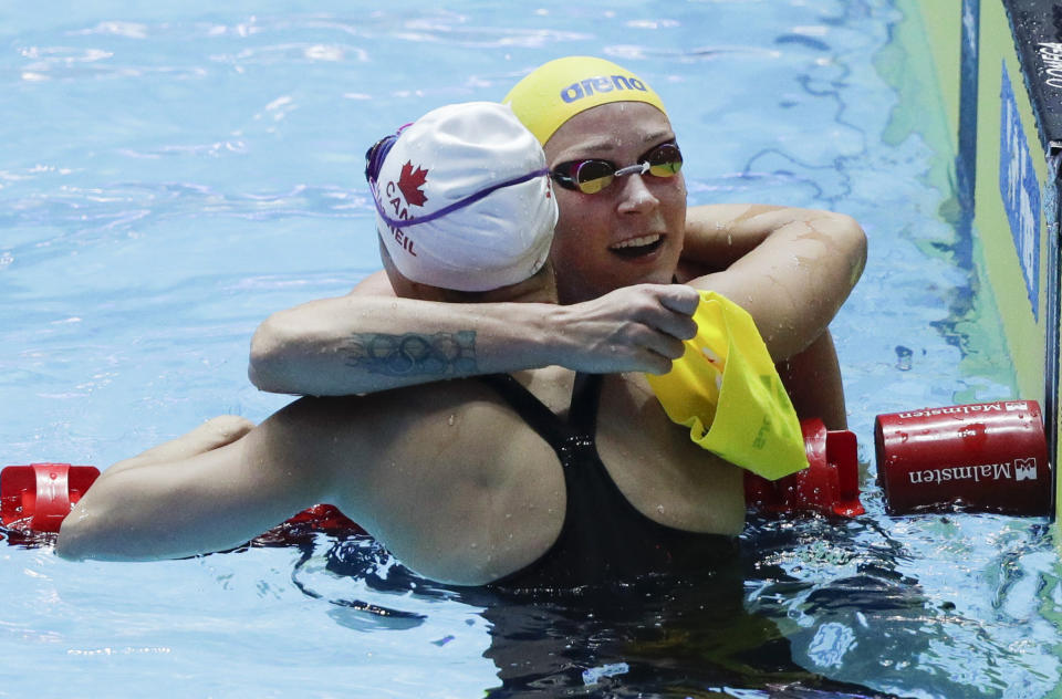 Sweden's Sarah Sjostrom, right, congratulates Canada's Margaret MacNeil after winning the women's 100m butterfly final at the World Swimming Championships in Gwangju, South Korea, Monday, July 22, 2019. (AP Photo/Mark Schiefelbein)