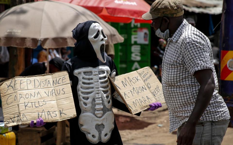 James Kiriva, who took the initiative to educate his community about the importance of taking precautions to curb the spread of the coronavirus walks around Kiberia dressed as a skeleton to spread his message in English and Swahili - AP Photo/Brian Inganga