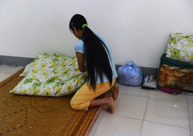 H'mong ethnic girl Kiab (whose name has been changed to protect her identity) makes her bed at a government-run centre for trafficked women in the northern city of Lao Cai, May 9, 2014