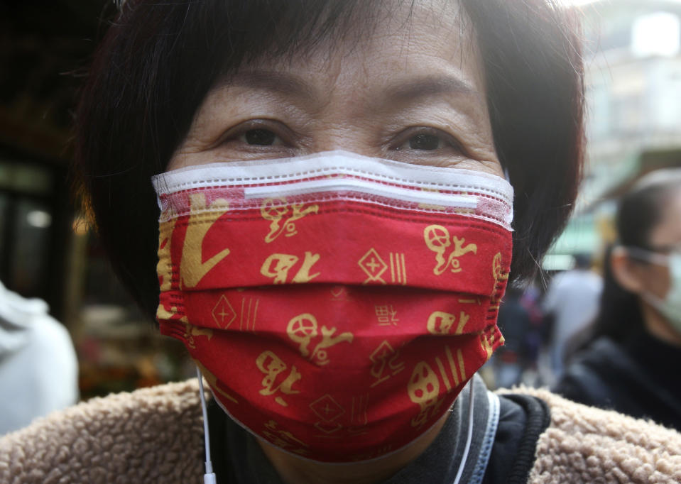 A woman wears a Chinese auspicious character "Fu (good fortune)"-patterned mask to help curb the spread of the coronavirus as they shop at a market in Taipei, Taiwan, Monday, Jan. 25, 2021. (AP Photo/Chiang Ying-ying)