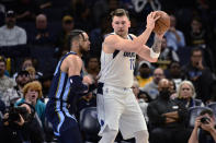 Dallas Mavericks guard Luka Doncic (77) keeps the ball from Memphis Grizzlies forward Dillon Brooks during the first half of an NBA basketball game Wednesday, Dec. 8, 2021, in Memphis, Tenn. (AP Photo/Brandon Dill)