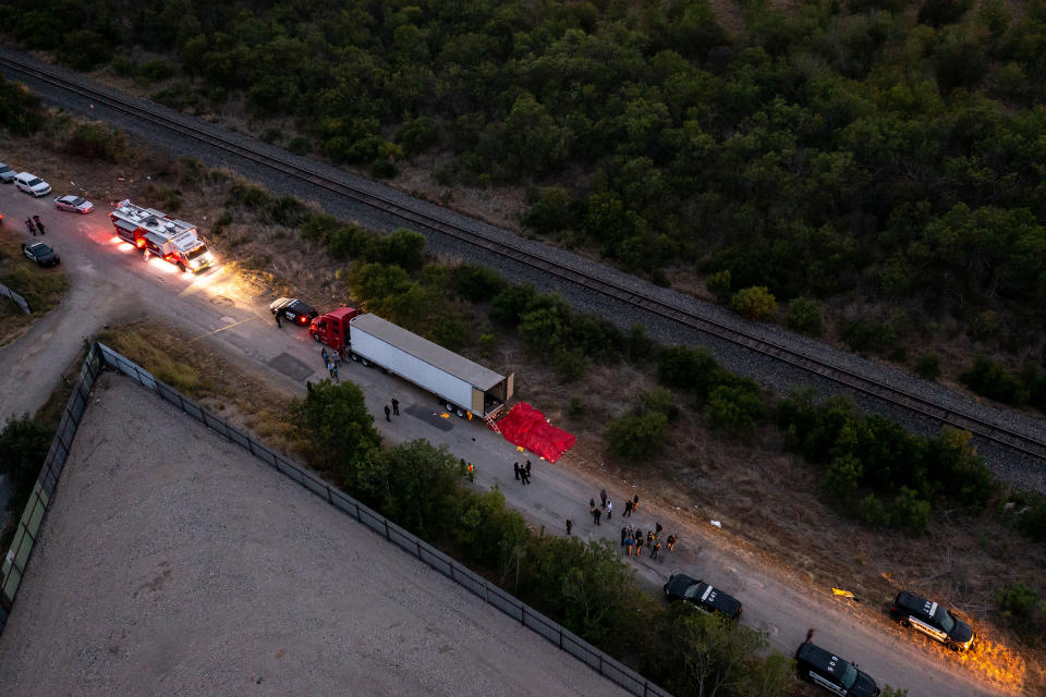 In this aerial view, members of law enforcement investigate a tractor trailer on June 27, 2022 in San Antonio, Texas. Several victims were found alive, suffering from heat stroke and taken to local hospitals.<span class="copyright">Jordan Vonderhaar—Getty Images</span>