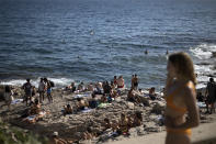 ARCHIVO - En esta imagen de archivo del 25 de julio de 2020, gente disfrutando del sol en la playa de Malmousque en Marsella, sur de Francia. ARCHIVO - En esta imagen del martes 28 de julio de 2020, gente tomando el sol junto al río Sena en París. Un brote de coronavirus en una zona turística de Francia se está convirtiendo en un ejemplo de manual de cómo el virus enfrenta generaciones entre sí. En una semana se han descubierto 72 casos, la mayoría en veraneantes y trabajadores de temporada entre 18 y 25 años. (AP Foto/Daniel Cole, Archivo)