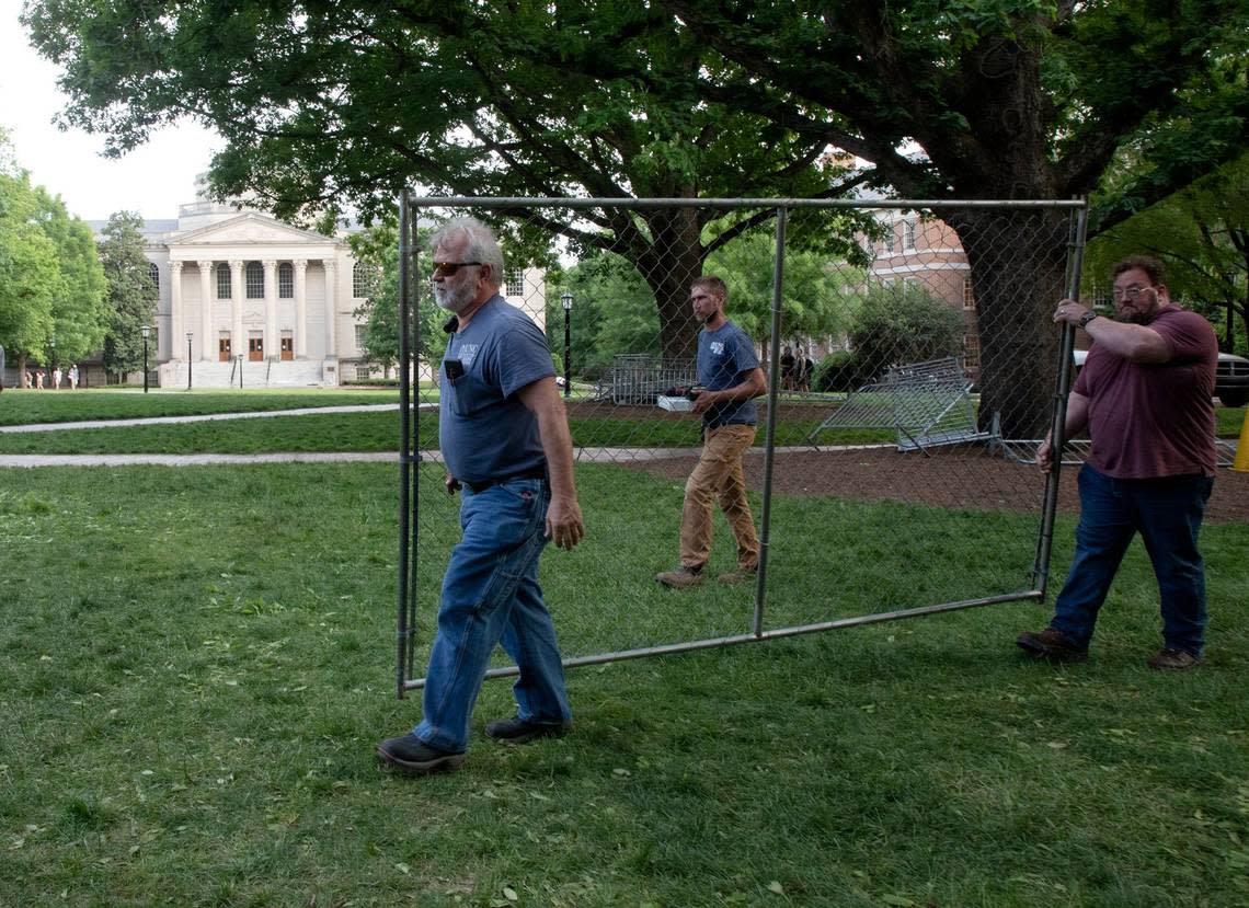 Facilities services staff carry a piece of fencing to construct a barrier around a flagpole on the campus of UNC-Chapel Hill on Tuesday, April 30, 2024. UNC-Chapel Hill police charged 36 members of a pro-Palestinian “Gaza solidarity encampment” Tuesday morning after warning the group to remove its tents from campus or face possible arrest, suspension or expulsion from the university. Earlier in the afternoon, protesters took an American flag down from the flagpole and then mounted a Palestinian flag in its place.