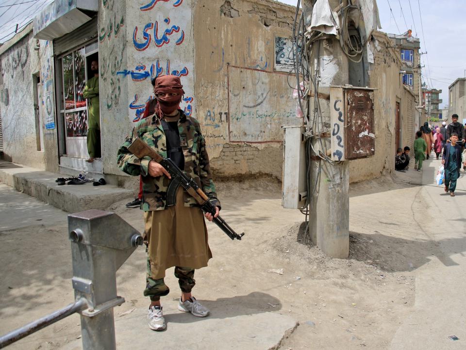 A Taliban fighter stands guard at the site of an explosion in Kabul, Afghanistan, April 19, 2022