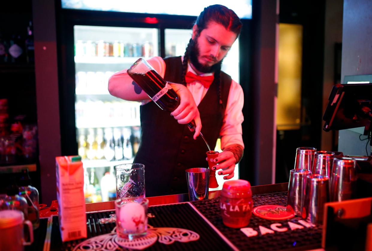 Parker Fernandes makes cocktails at Ponyboy in Oklahoma City, Wednesday, Dec. 7, 2022. The bar has converted into a Christmas-themed pop-up bar, "Miracle on 23rd Street."