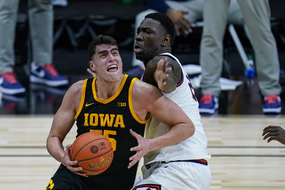 Illinois center Kofi Cockburn, right, defends against Iowa center Luka Garza (55) in the first half of an NCAA college basketball game at the Big Ten Conference tournament in Indianapolis, Saturday, March 13, 2021. (AP Photo/Michael Conroy)