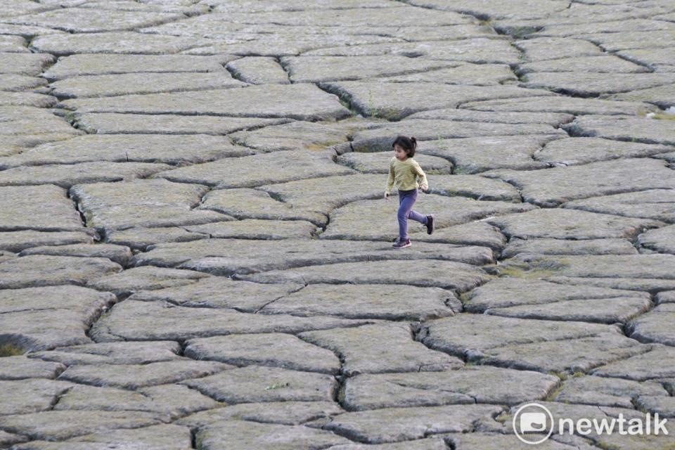 一位小朋友在日月潭大竹湖附近龜裂的湖底奔跑。   圖：張良一/攝