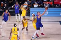 Denver Nuggets center Nikola Jokic, right, goes up for a shot after getting past Los Angeles Lakers' Rajon Rondo (9) and Anthony Davis, second from right, during the first half an NBA conference final playoff basketball game, Friday, Sept. 18, 2020, in Lake Buena Vista, Fla. (AP Photo/Mark J. Terrill)