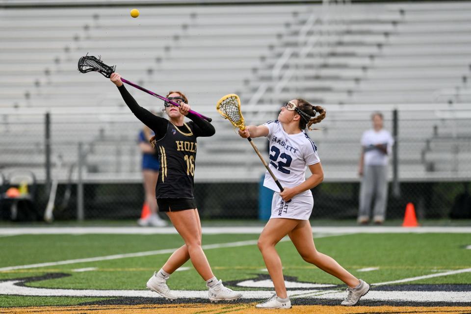 Haslett-Williamston's Abby Russell, right, and Holt's Hadlei Olson battle for the ball in a face off during the second half on Monday, May 8, 2023, at Haslett High School.