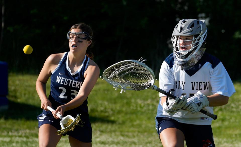 Westerly Bulldog Casey Macera and Bay View Bengals goalie Kate Shields watch as a ball bounces away from them behind the Bay View net during first half action.