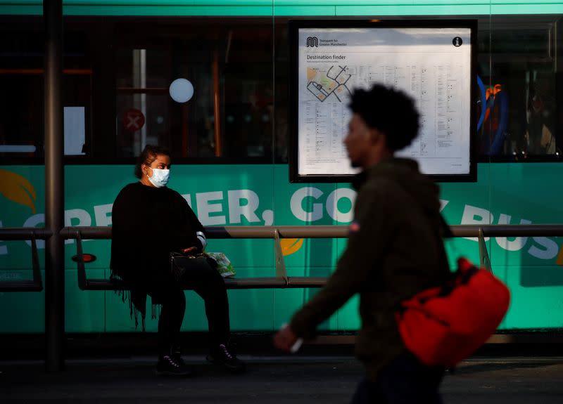 Una mujer porta una máscarilla protectora mientras espera el autobús en Mánchester, Reino Unido