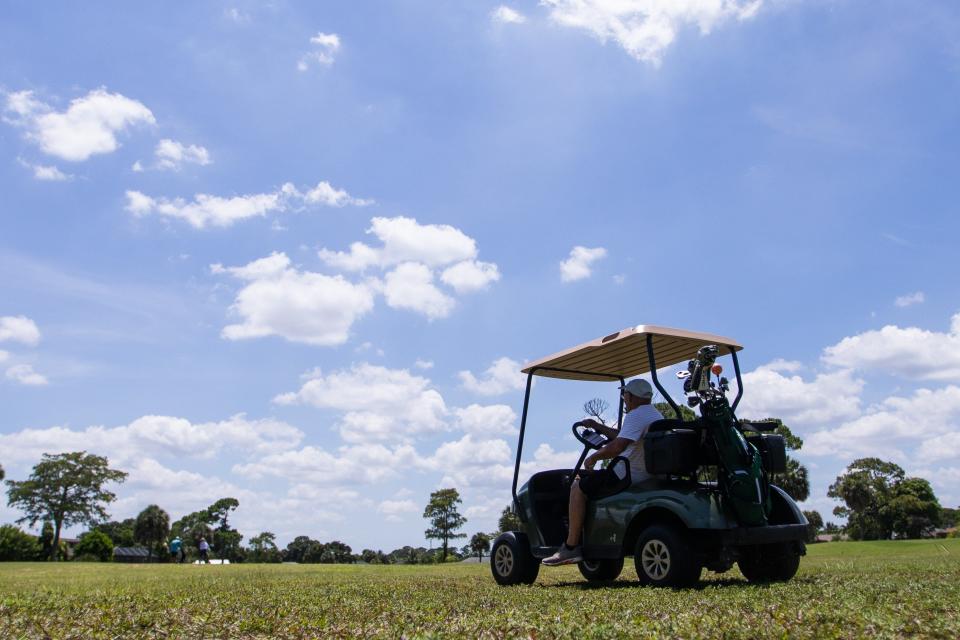 A guest at Lone Pine Golf Club in Riviera Beach, FL., drives a golf cart towards the 13th hole on Thursday, June 23, 2022. Riviera Beach City Council members are expected to decide in August whether to approve a request to have the roughly 64-acre Long Pine Golf Course site rezoned.