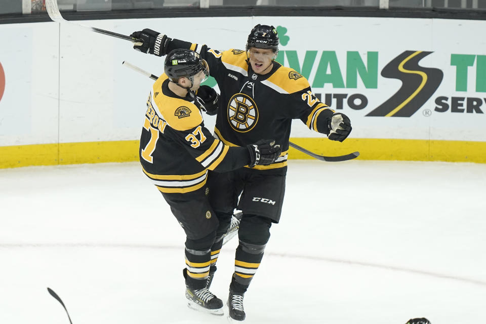 Boston Bruins center Patrice Bergeron (37) and defenseman Hampus Lindholm (27) celebrate after Lindholm scored in the first period of an NHL hockey game against the San Jose Sharks, Sunday, Jan. 22, 2023, in Boston. (AP Photo/Steven Senne)